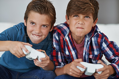 Buy stock photo Shot of two young boys playing video games at home