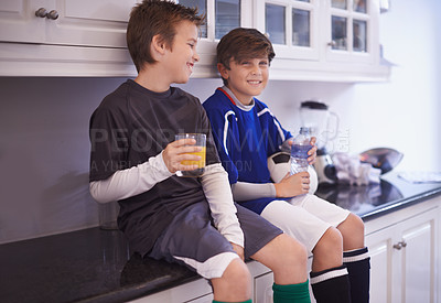 Buy stock photo Cropped shot of two young boys having cold drinks after soccer practice