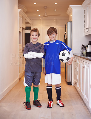 Buy stock photo Children, friends and portrait with soccer ball at house or training game in kit or competition, cardio or apartment. Male people, face and football in kitchen or player practice, exercise or workout