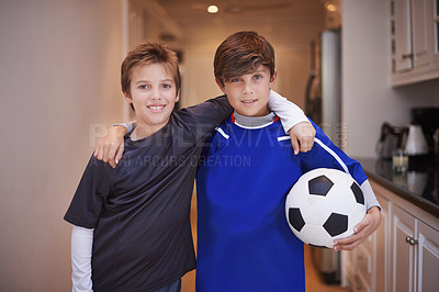 Buy stock photo Portrait of two young boys in sports clothing standing indoors with a soccer ball