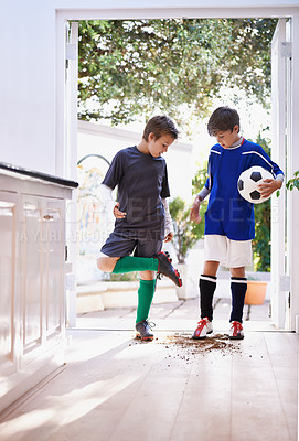 Buy stock photo Shot of two boys bringing dirt into the house after soccer practice