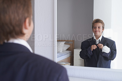 Buy stock photo Shot of a young boy wearing his father's suit and pretending to be a businessman