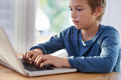 Buy stock photo Shot of a young boy using a laptop at home