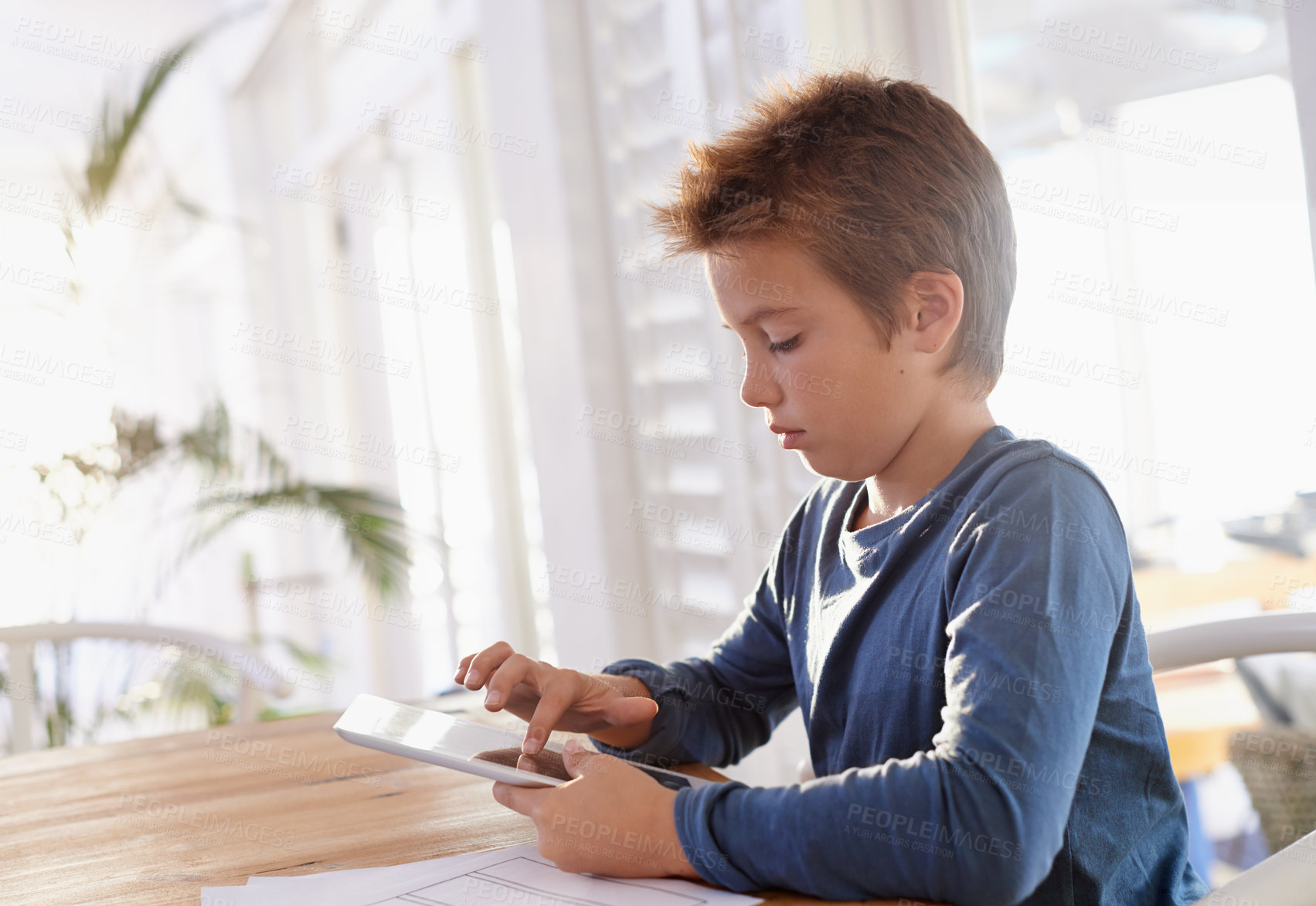 Buy stock photo Child, tablet and notes in house for homework, elearning and games on table with internet and online. Young boy or kid  with technology and finger on screen for touch, scroll or study for education 