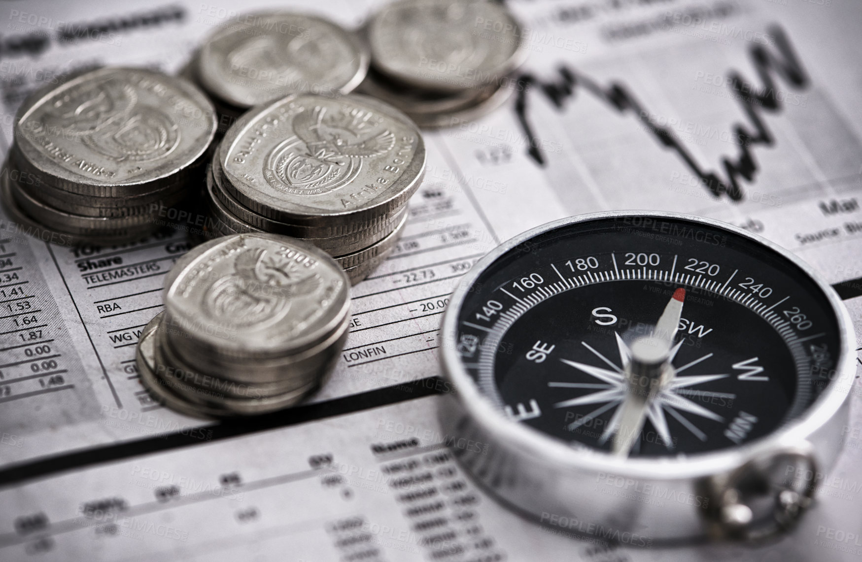 Buy stock photo Studio shot of coins and a compass on the business section of a newspaper