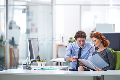 Buy stock photo Young business professionals discussing work documents