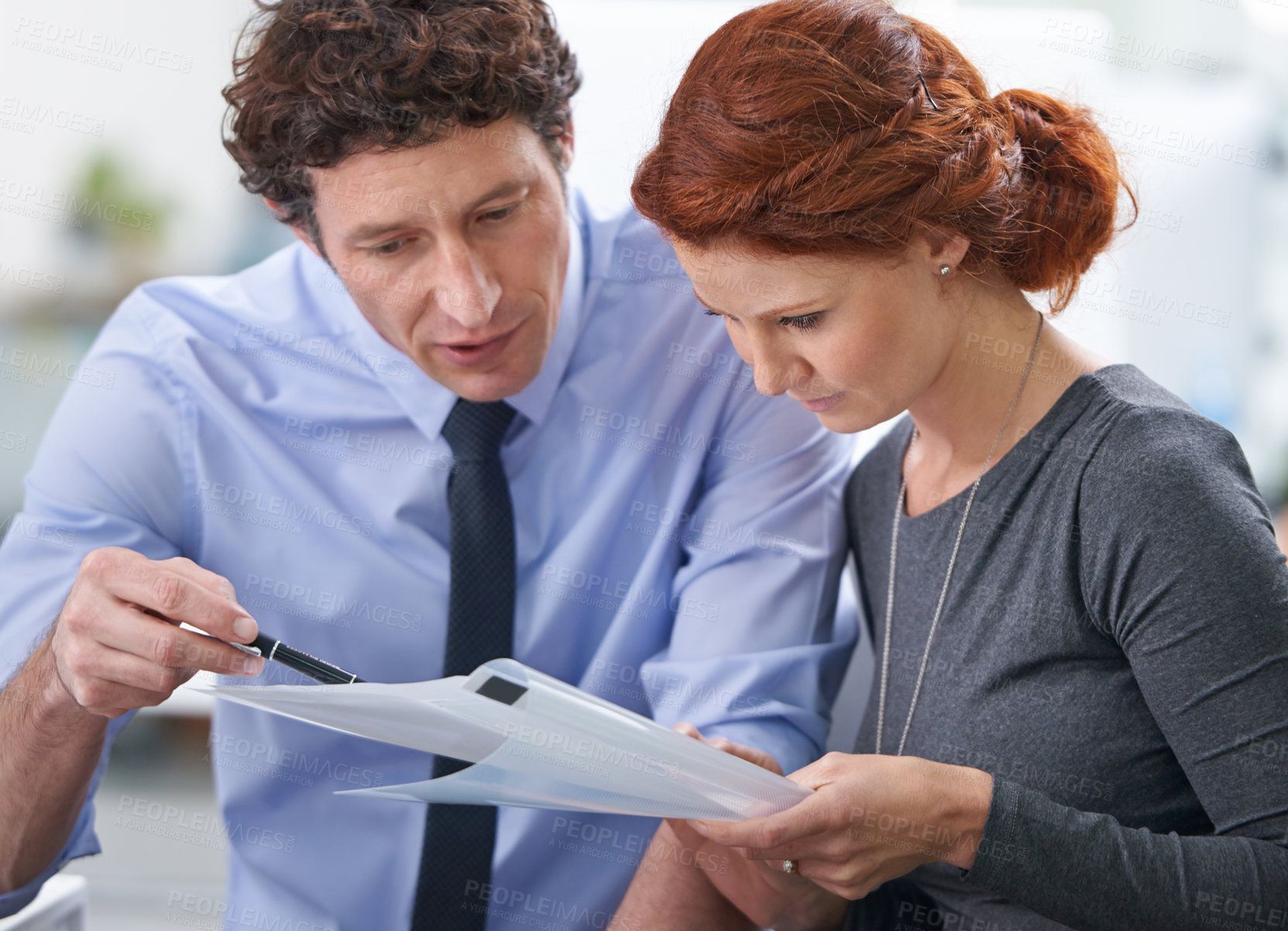 Buy stock photo Young business professionals discussing work documents