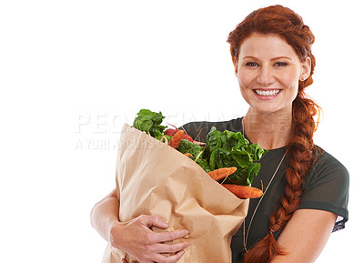 Buy stock photo Studio shot of a beautiful young woman holding a shopping bag full of fresh vegetables