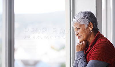 Buy stock photo Shot of a mature woman standing by a window on a sunny day