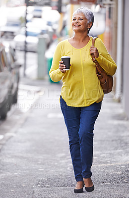 Buy stock photo Shot of a mature woman on a sidewalk holding a takeaway beverage