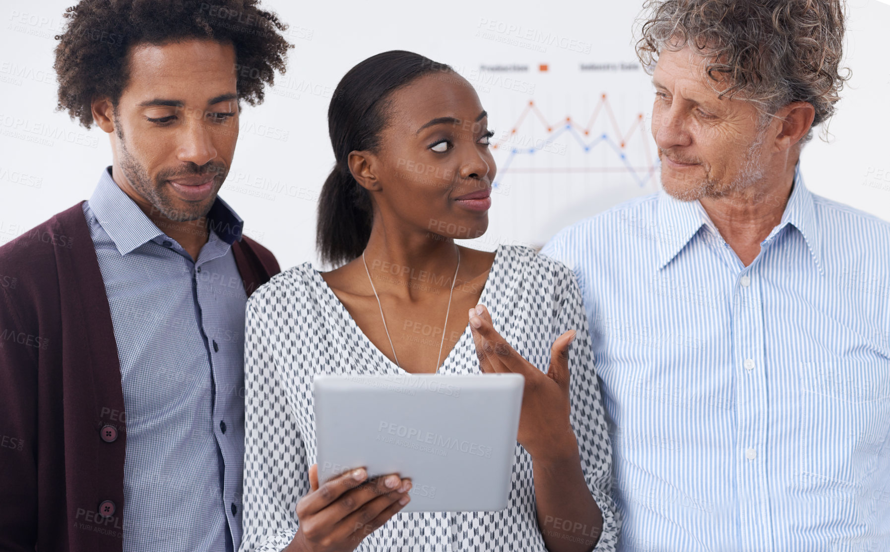 Buy stock photo A businesswoman holding a tablet while having a discussion with her coworkers