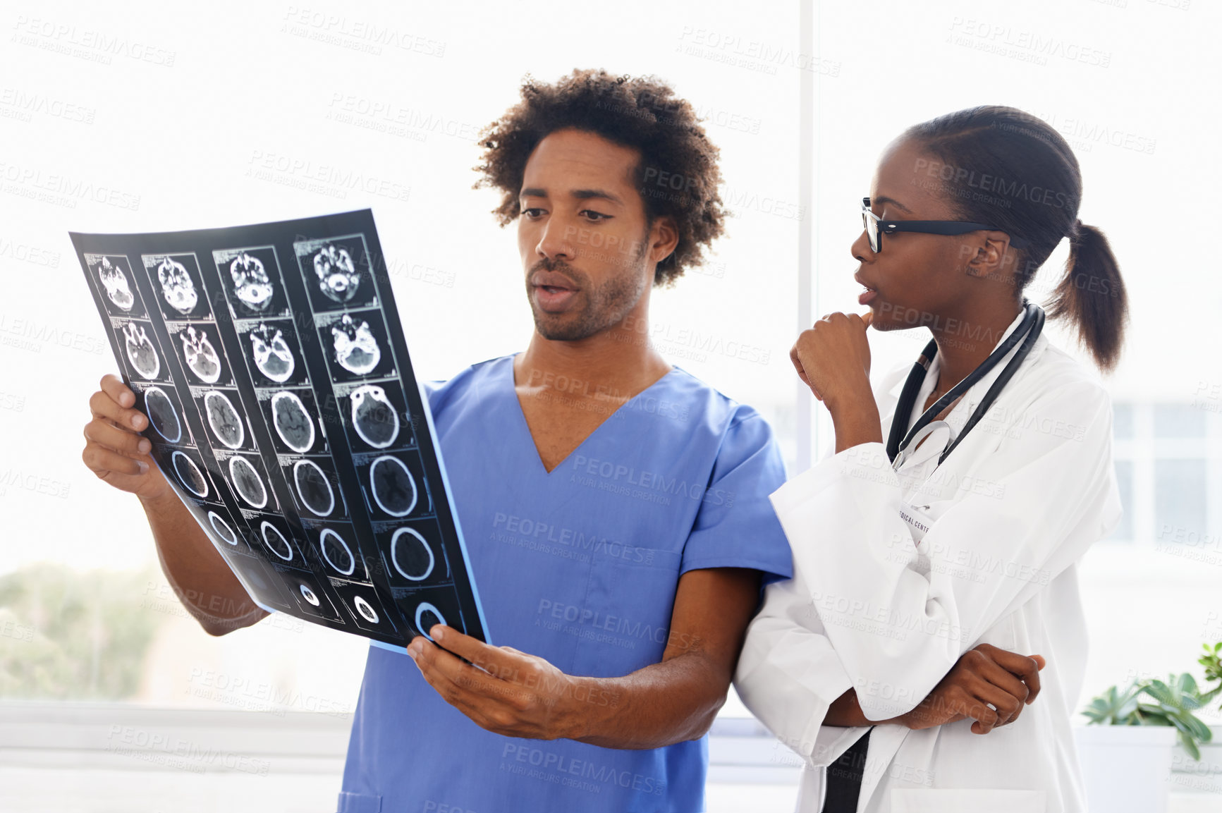 Buy stock photo Shot of a female doctor and male nurse studying a CAT scan