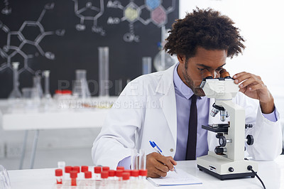 Buy stock photo Shot of a male biologist looking at a glass slide through a microscope