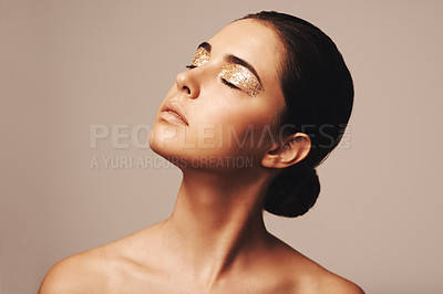Buy stock photo Woman, eyeshadow and gold glitter on eyes for beauty, cosmetology and glamour with cosmetics on beige background. Makeup, elegance and fashion model in studio, art or creativity with shimmer and glow