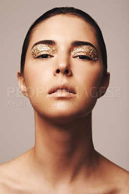 Buy stock photo Woman, portrait and gold glitter on eyes for beauty, cosmetology and glamour with cosmetics on beige background. Eyeshadow, makeup and fashion model in studio, art or creativity with shimmer and glow