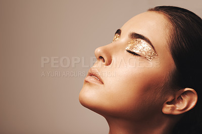 Buy stock photo Woman, face and gold glitter on eyes for beauty, cosmetology and glamour with cosmetics on beige background. Eyeshadow, makeup and fashion model in studio, art or creativity with shimmer and glow