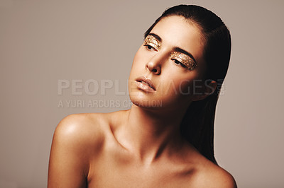 Buy stock photo Woman, makeup and gold eyeshadow for beauty, cosmetology and glamour with cosmetics on beige background. Glitter on eyes, elegance and fashion model in studio, art or creativity with shimmer and glow