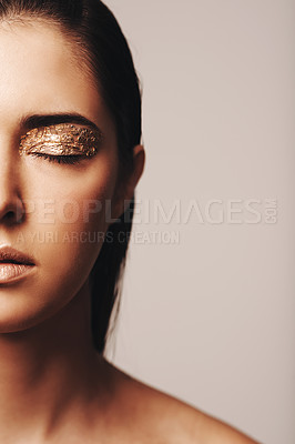 Buy stock photo Cropped shot of half of a beautiful woman's face which has beenpainted with golden flakes around her eyes