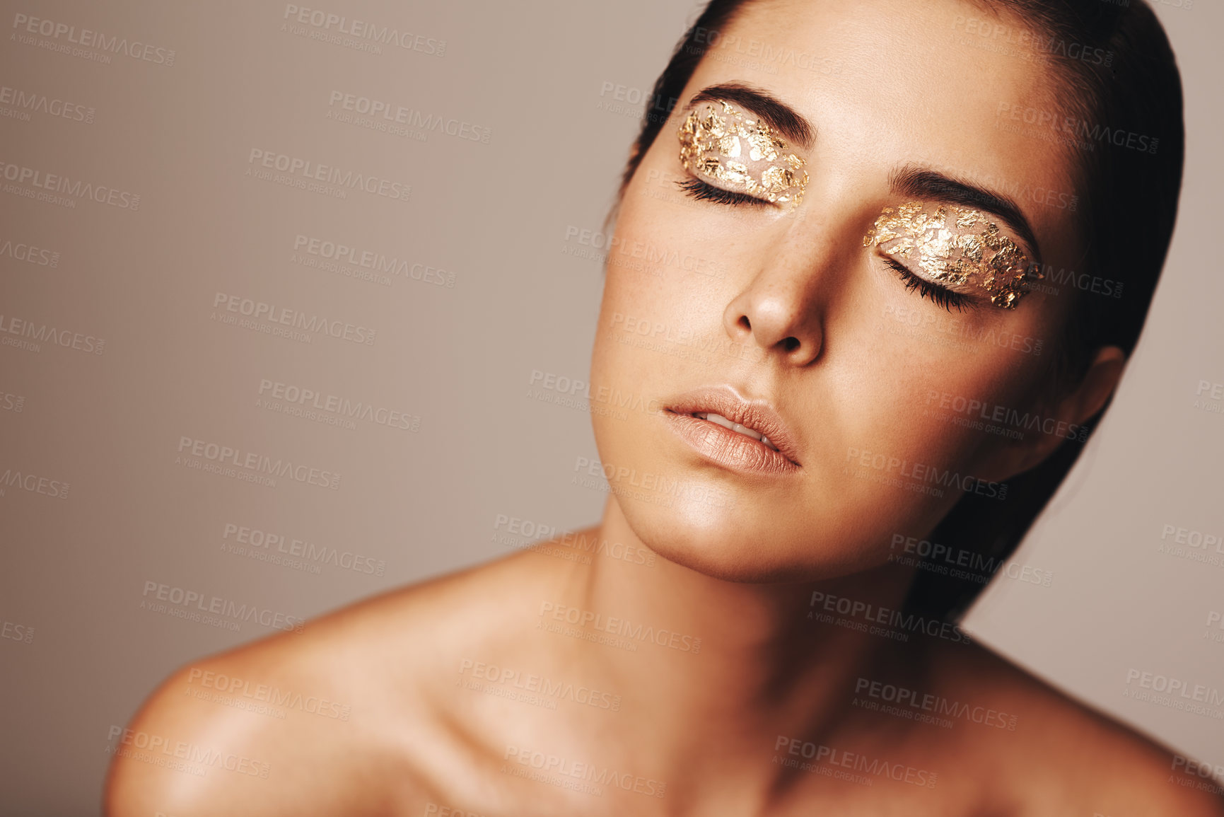 Buy stock photo Studio shot of a beautiful woman with eyes closed and gold eye makeup