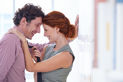 Buy stock photo Couple, love and office romance with bonding, secret and happy staff at a company with a smile. Business people, workplace and flirt at a startup with employees together with embrace in relationship