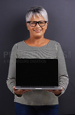 Buy stock photo Portrait of a mature woman  holding a laptop in a studio