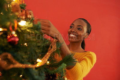 Buy stock photo Woman, Christmas and tree with decoration for holiday celebration with happiness, giving or present. Black person, smile and light for festive season on red background or break, relax or ornament