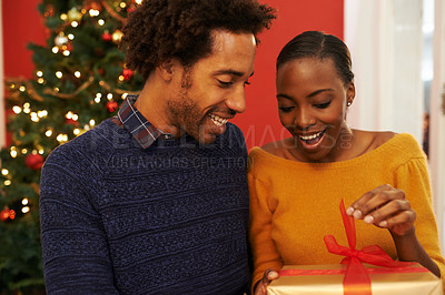 Buy stock photo Christmas, present and black couple giving a box or opening surprise on festive holiday or vacation with happiness. Excited, woman and man offer a gift in home with love and kindness in marriage