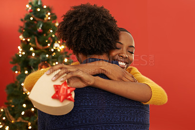 Buy stock photo Christmas, present and black couple in hug with box or opening surprise on festive holiday or vacation with happiness. Embrace, woman and man offer a gift in home with love and kindness in marriage