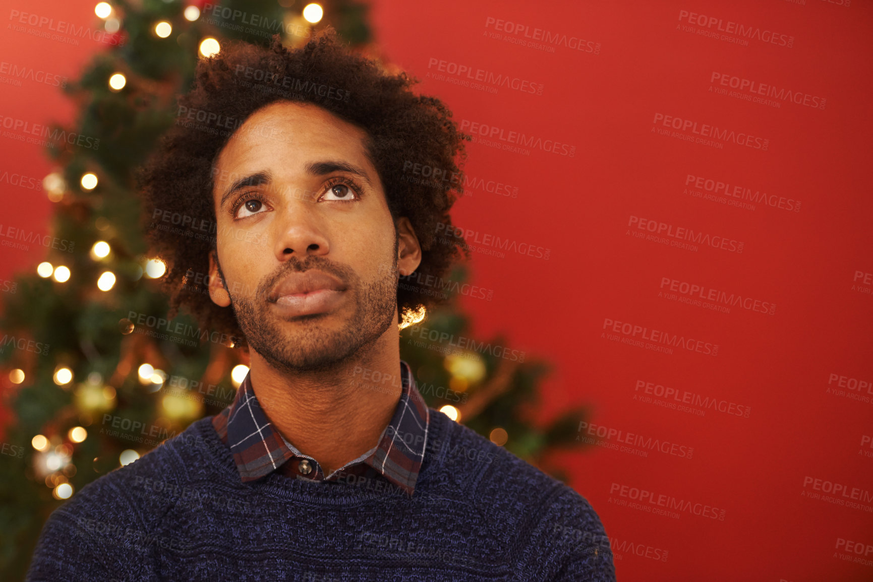 Buy stock photo Man, thinking and Christmas holiday at tree for festive season thoughts for present, vacation or celebration. Male person, contemplating and red background with mockup space, decoration or lights