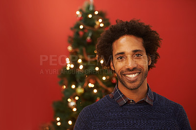 Buy stock photo Man, portrait and smile at Christmas holiday for relax weekend for festive season, red background or mockup space. Male person, face and happy or ornament decoration or present, giving or celebration