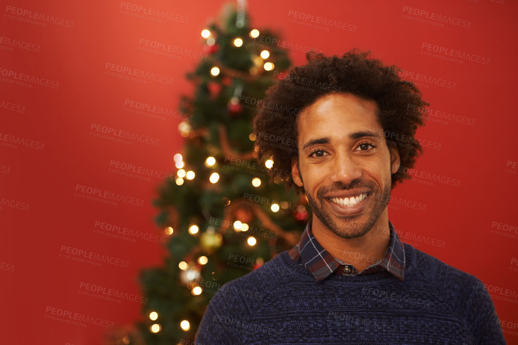 Buy stock photo Man, portrait and smile at Christmas holiday for relax weekend for festive season, red background or mockup space. Male person, face and happy or ornament decoration or present, giving or celebration