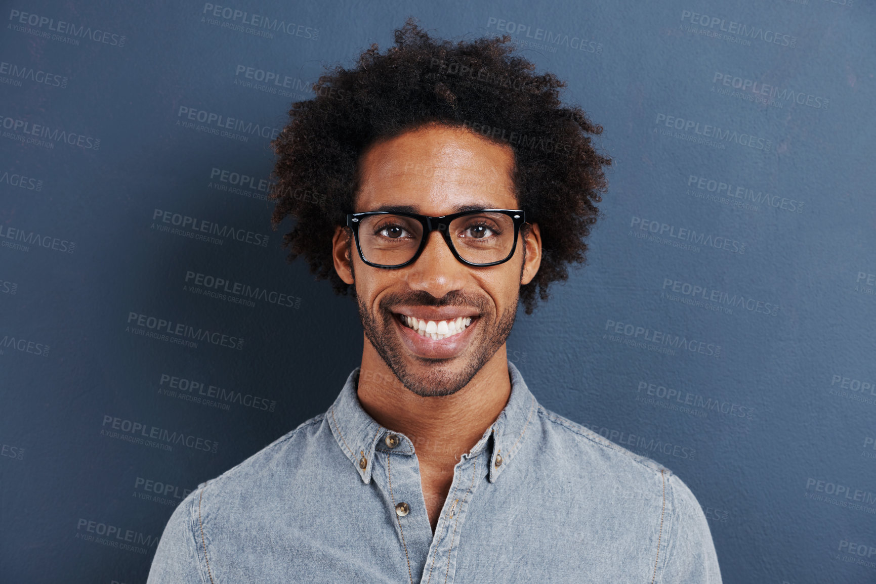 Buy stock photo Happy man, portrait and glasses with frame in studio and curly afro in trendy eyewear for optometry. Model, face and consultant in fashion spectacles, vision and smile for eyecare by blue background
