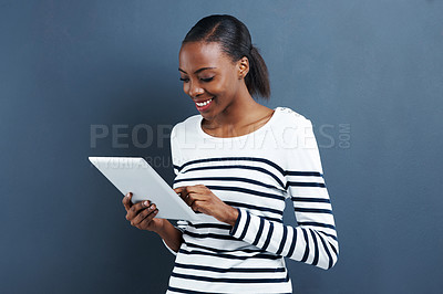 Buy stock photo Black woman, tablet and technology for social media or internet connection, research or browsing on blue background. Reading, streaming and notification with ebook or blog, email and connectivity