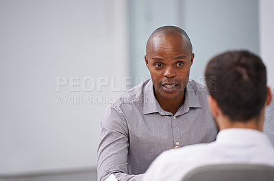 Buy stock photo A manager sitting and having a discussion with an employee