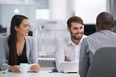 Buy stock photo Three happy coworkers sitting down to have a meeting