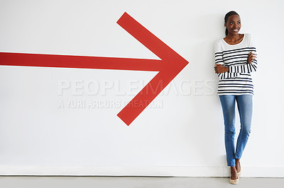Buy stock photo A big red arrow pointing to a stylish woman standing and smiling