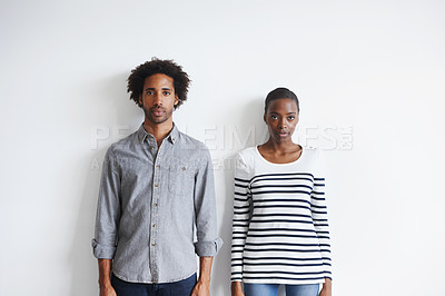 Buy stock photo Couple, serious and portrait by white wall in fashion with confidence, casual style and model aesthetic. Black woman, and face of man with trendy apparel, edgy clothes and pride with calm expression