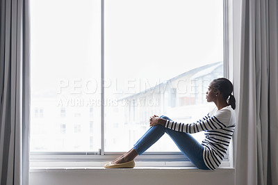 Buy stock photo A beautiful young woman lost in thought while sitting on a window sill