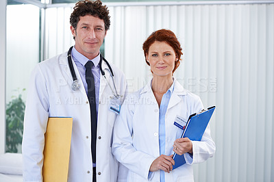 Buy stock photo Doctors, man and woman with smile in portrait for team, partnership and documents with pride for healthcare. Medic employees, people and clipboard in clinic for collaboration, wellness and services