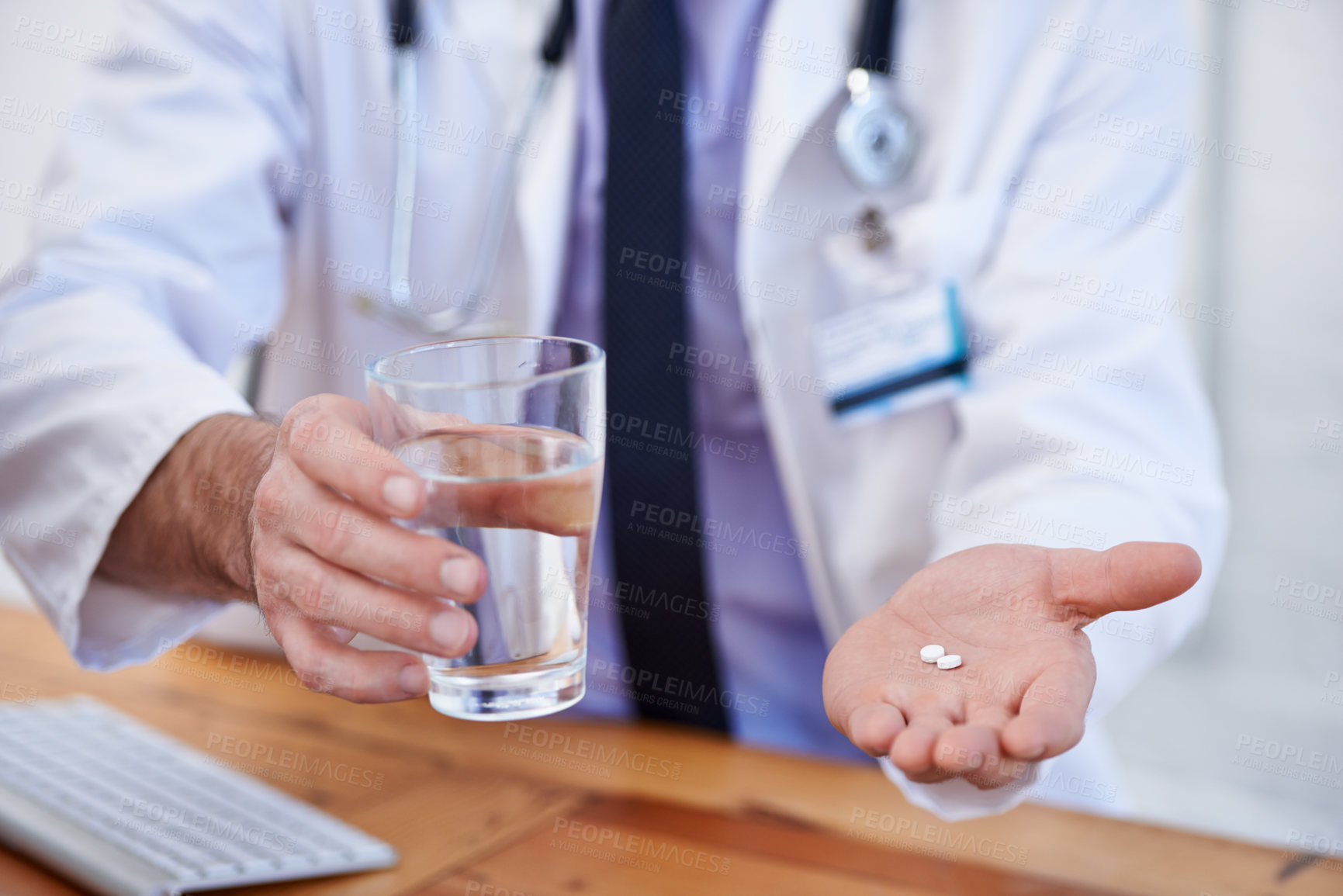 Buy stock photo Cropped shot of a male doctor holding a pill and glass of water