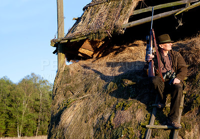 Buy stock photo Hunter, game shooting and man on a safari gun at outlook post for animal and wild hunting. Male person, poacher and hunter waiting for wildlife sports outdoor for scope watching at sunrise as a hobby