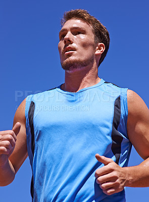 Buy stock photo Fitness, running and man outdoor for training, wellness or morning cardio, performance or routine on blue sky background. Health, exercise or male runner outside for summer run, marathon or challenge