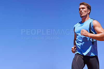Buy stock photo Cropped low angle shot of a young male athlete running in a race