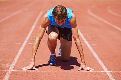 Buy stock photo Shot of a young male athlete at the start of a track race