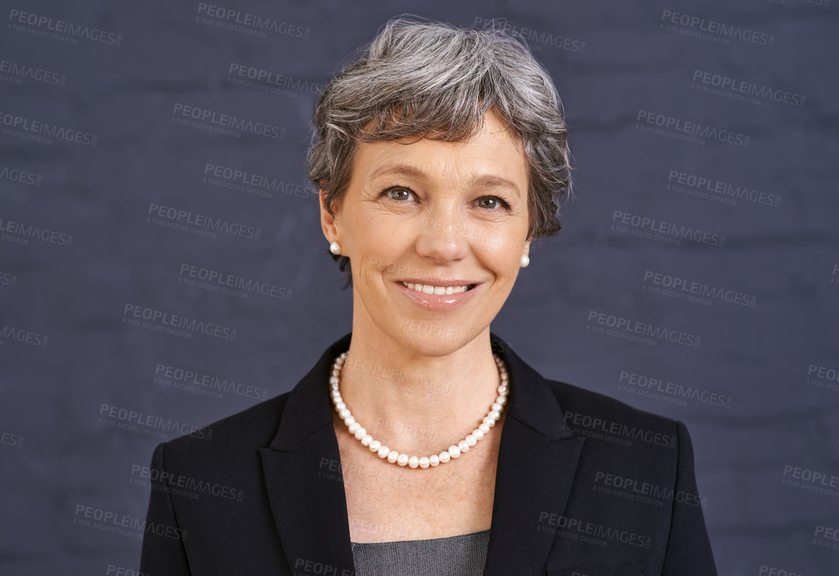 Buy stock photo Cropped shot of a senior businesswoman standing in front of a brick wall