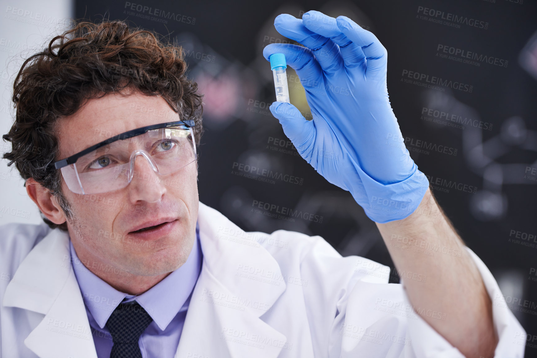 Buy stock photo A scientist looking at a sample in a test tube