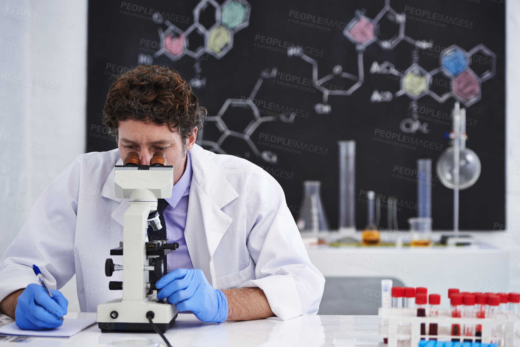 Buy stock photo Science, notes and man with microscope for research in chemistry, pathology and university class. Laboratory, investigation and scientist writing report on blood test for medical study with results