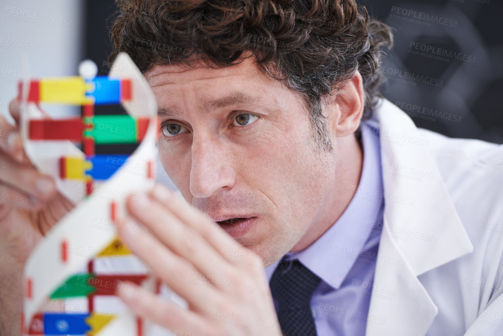 Buy stock photo A cropped shot of a scientist examining a DNA model