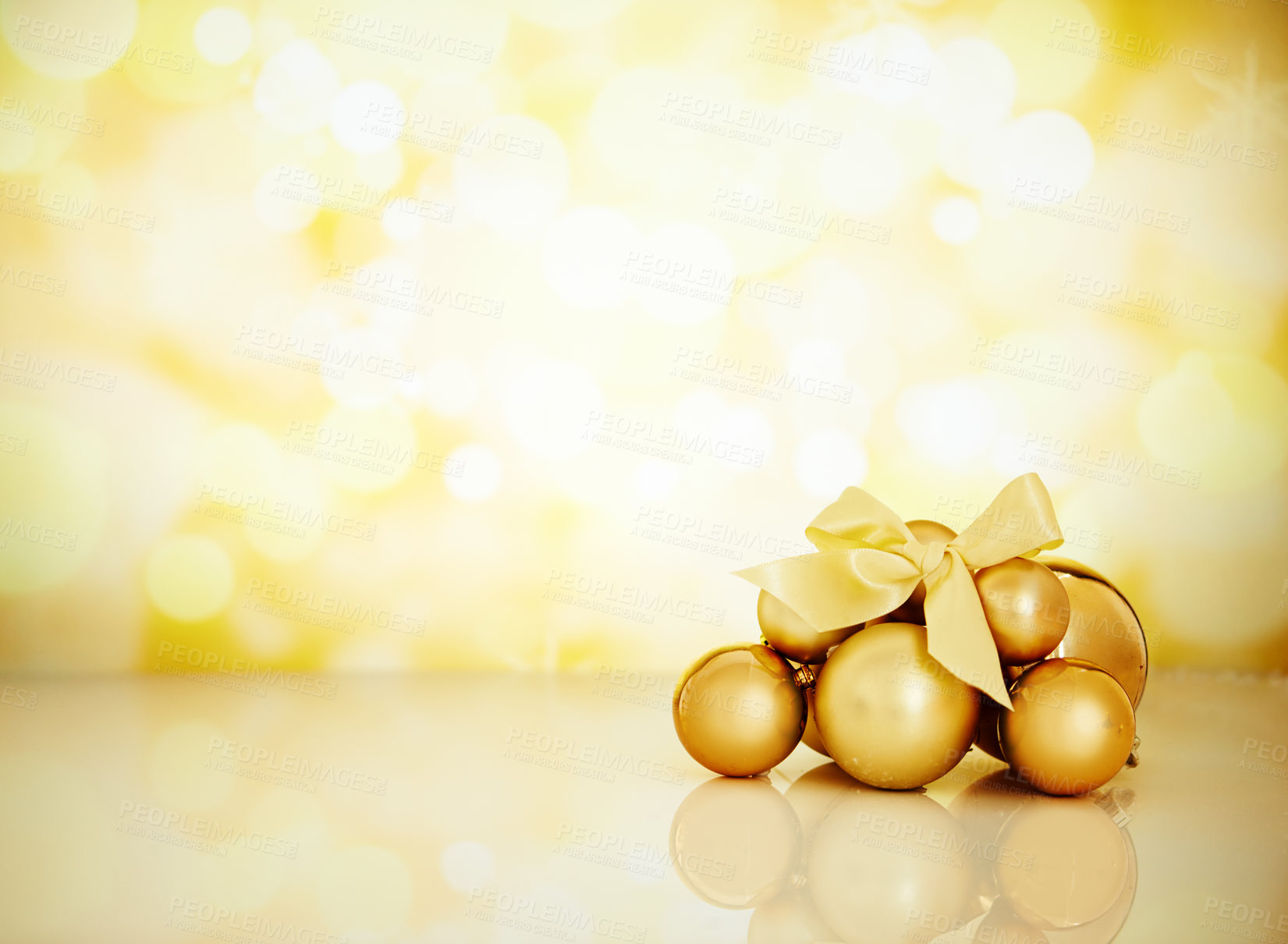 Buy stock photo Studio shot of Christmas ornaments against a gold background