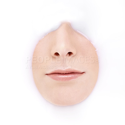 Buy stock photo Studio shot of a woman's mouth and nose emerging from milky liquid